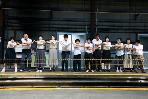 Sanriku 2016 - people crossing arms and holding hands on train platform